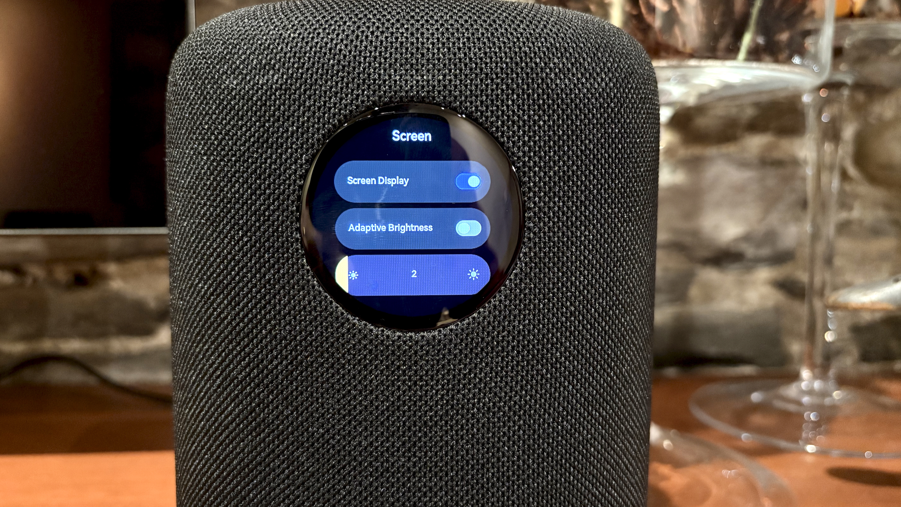 The WiiM Sound, in a home, on a varnished wooden table, showing the illuminated front panel 