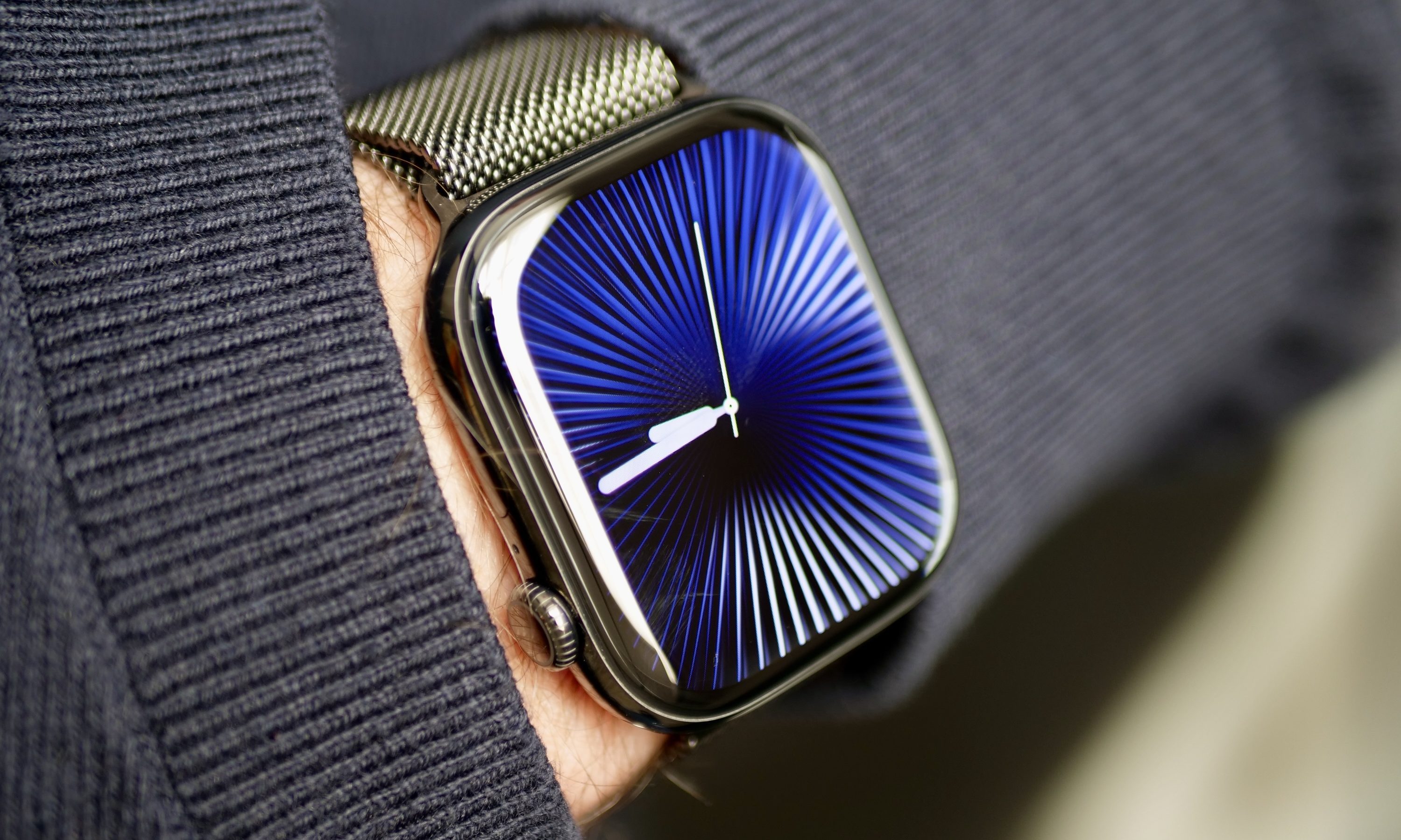 A person wearing the Apple Watch Series 10 in titanium with the Reflections watch face.