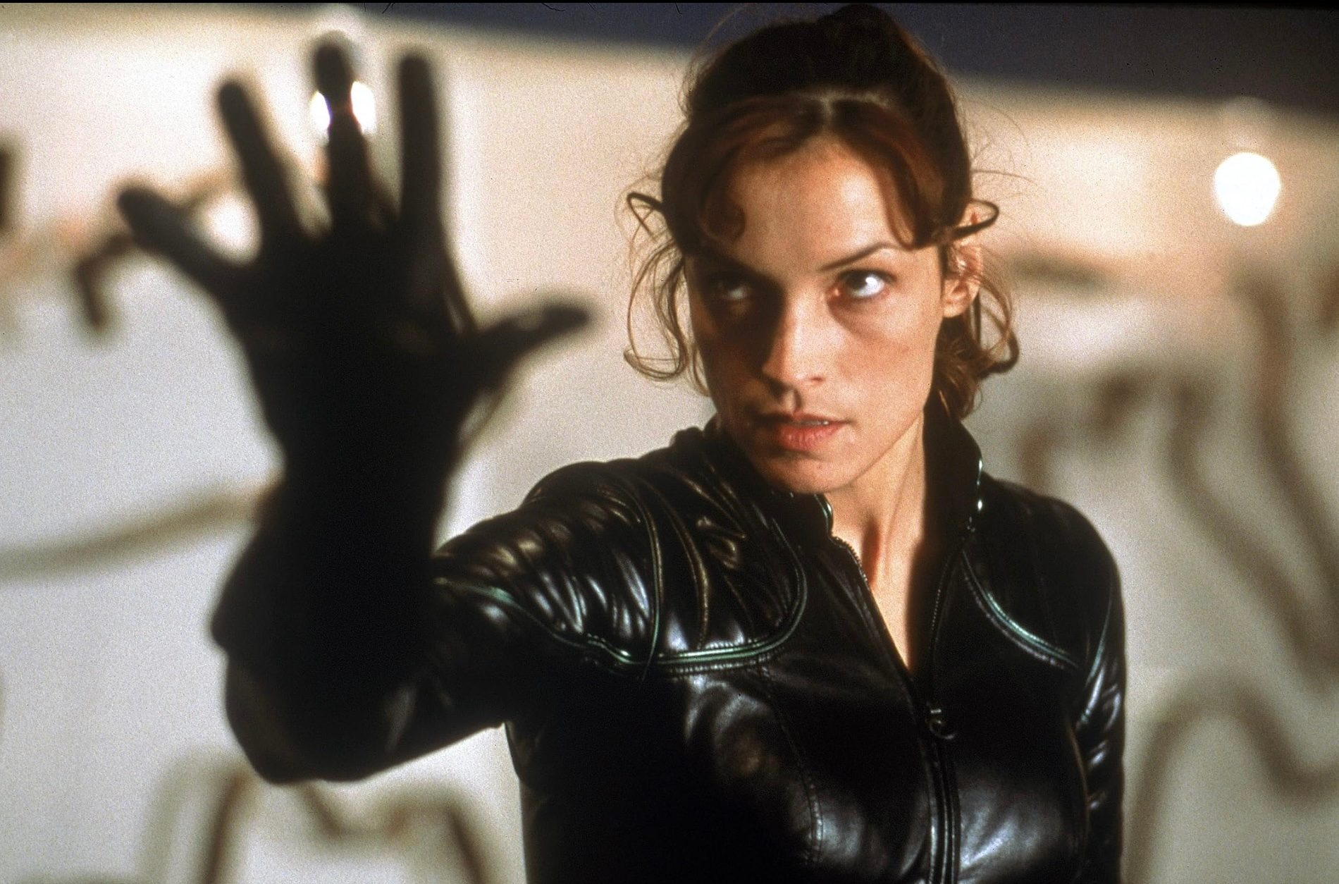 A woman puts her hand u and stares.