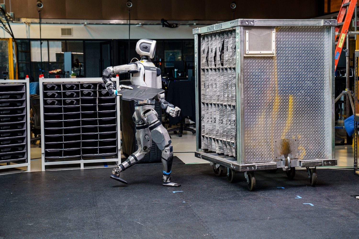 Boston Dynamics Atlas robot handling car engine covers.