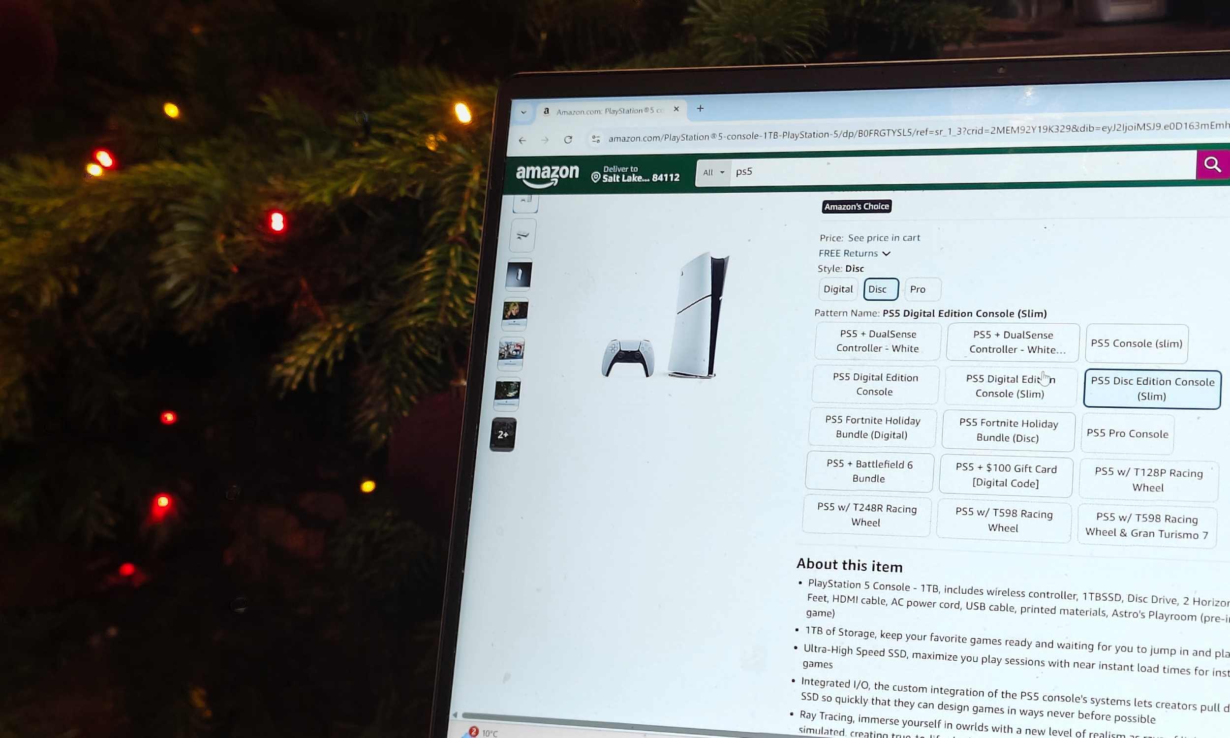 An Amazon listing for the PS5, on a laptop in front of a Christmas tree.