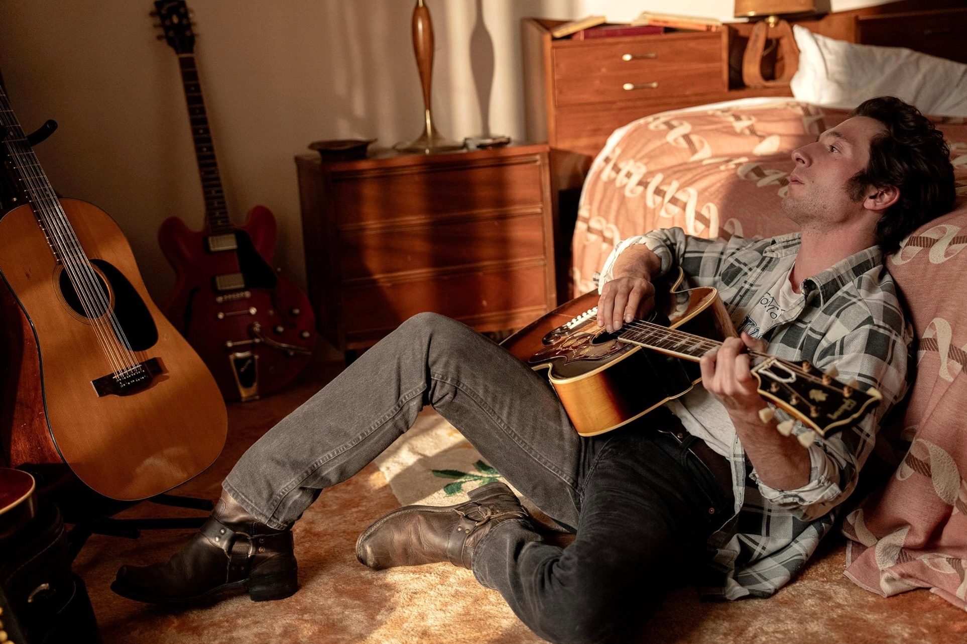 Jeremy Allen White sits down a strums a guitar.