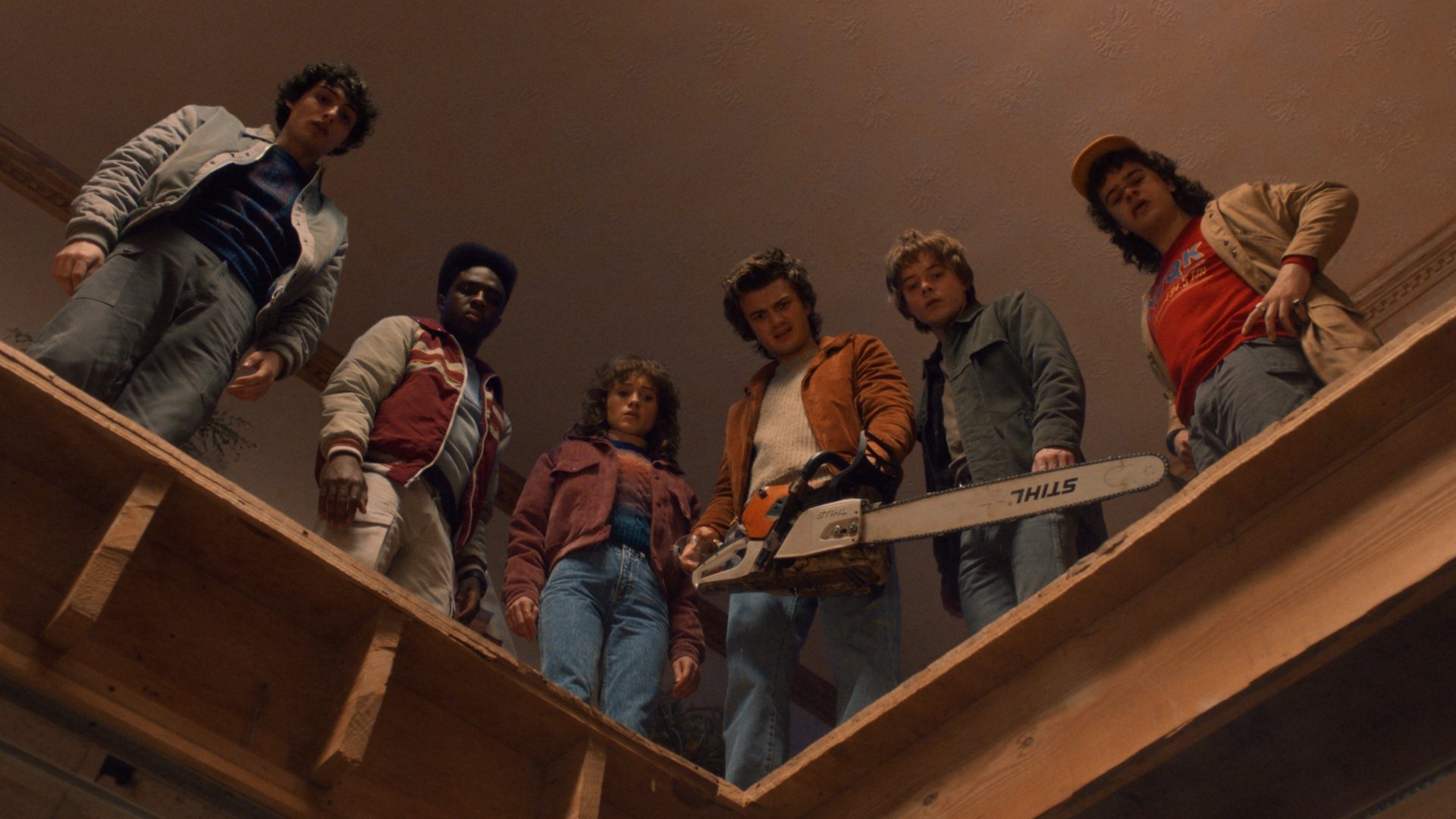 A group of teens look down as one holds a chainsaw in Stranger Things season 5.