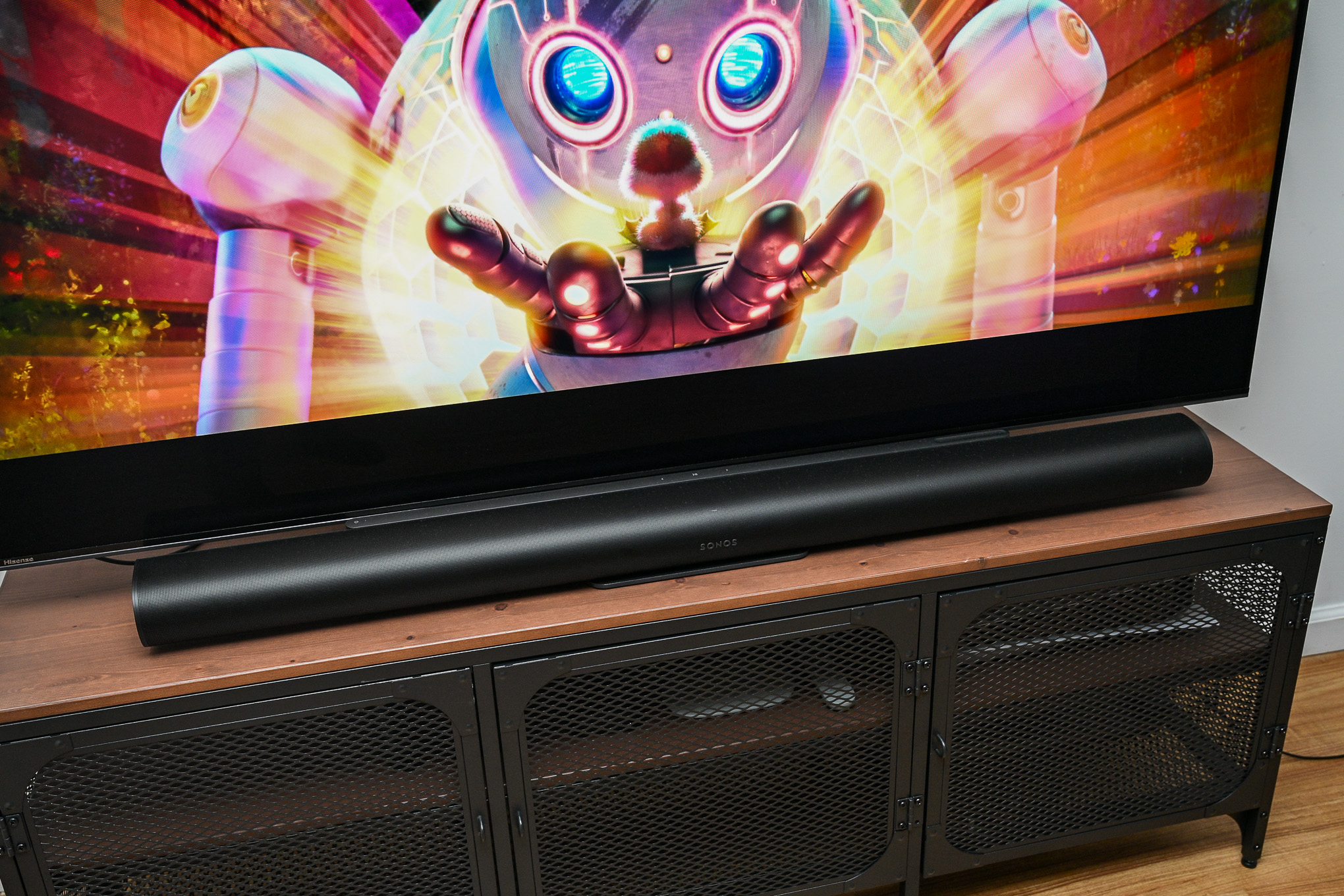 A photo of the Sonos Arc Ultra soundbar in front of a television on a stand.