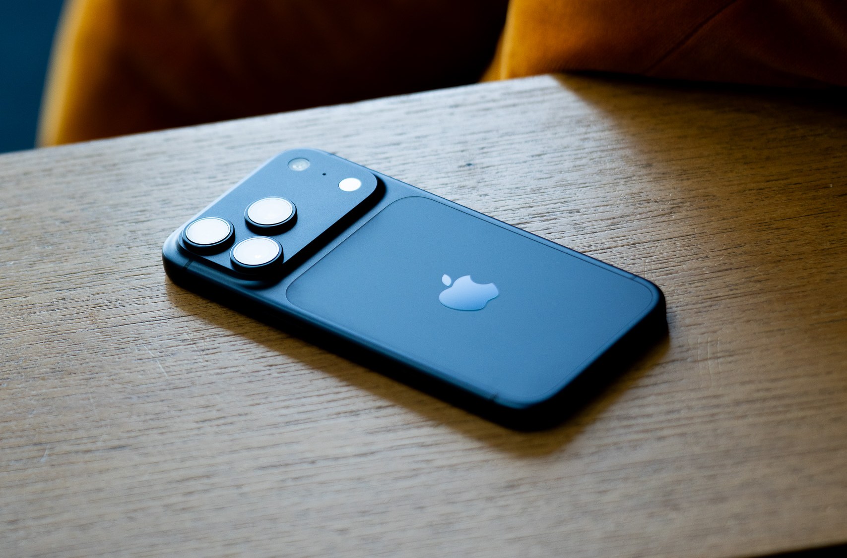 A navy blue iPhone on a wooden background