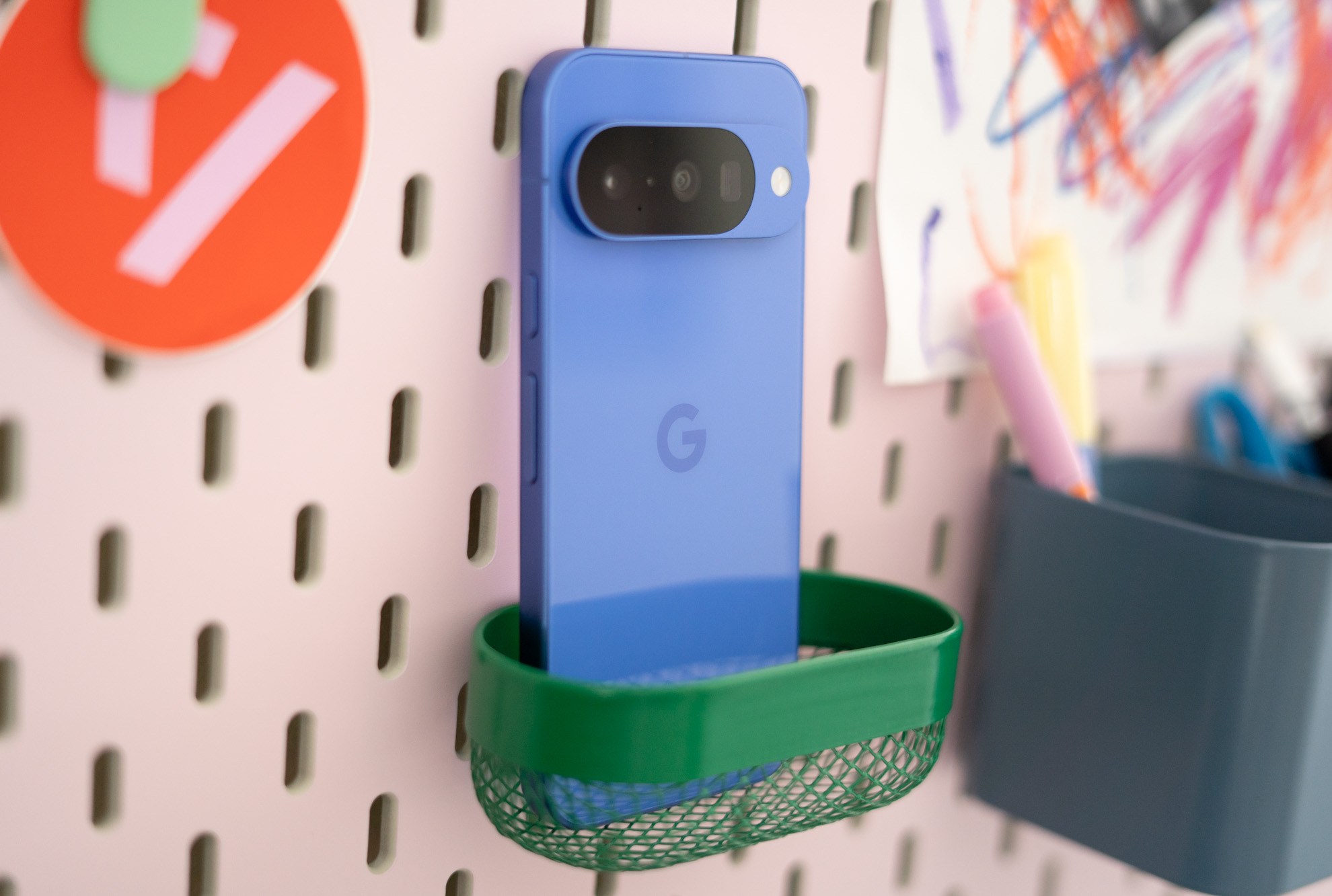 Google Pixel 10 in front of a colorful pegboard