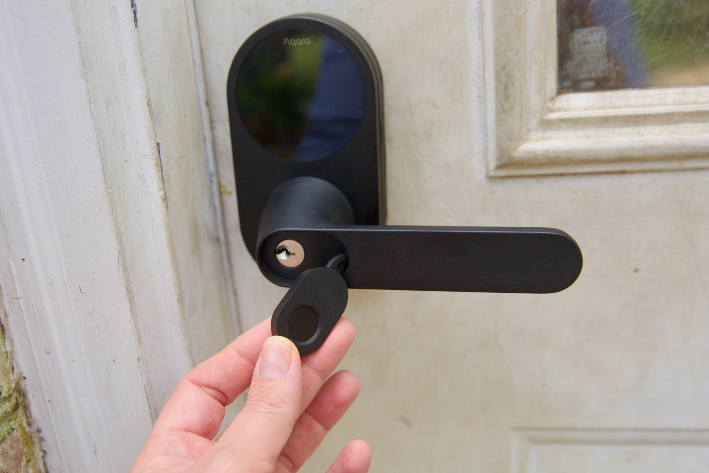 A smart key being used next to the Aqara U300 Smart Lock