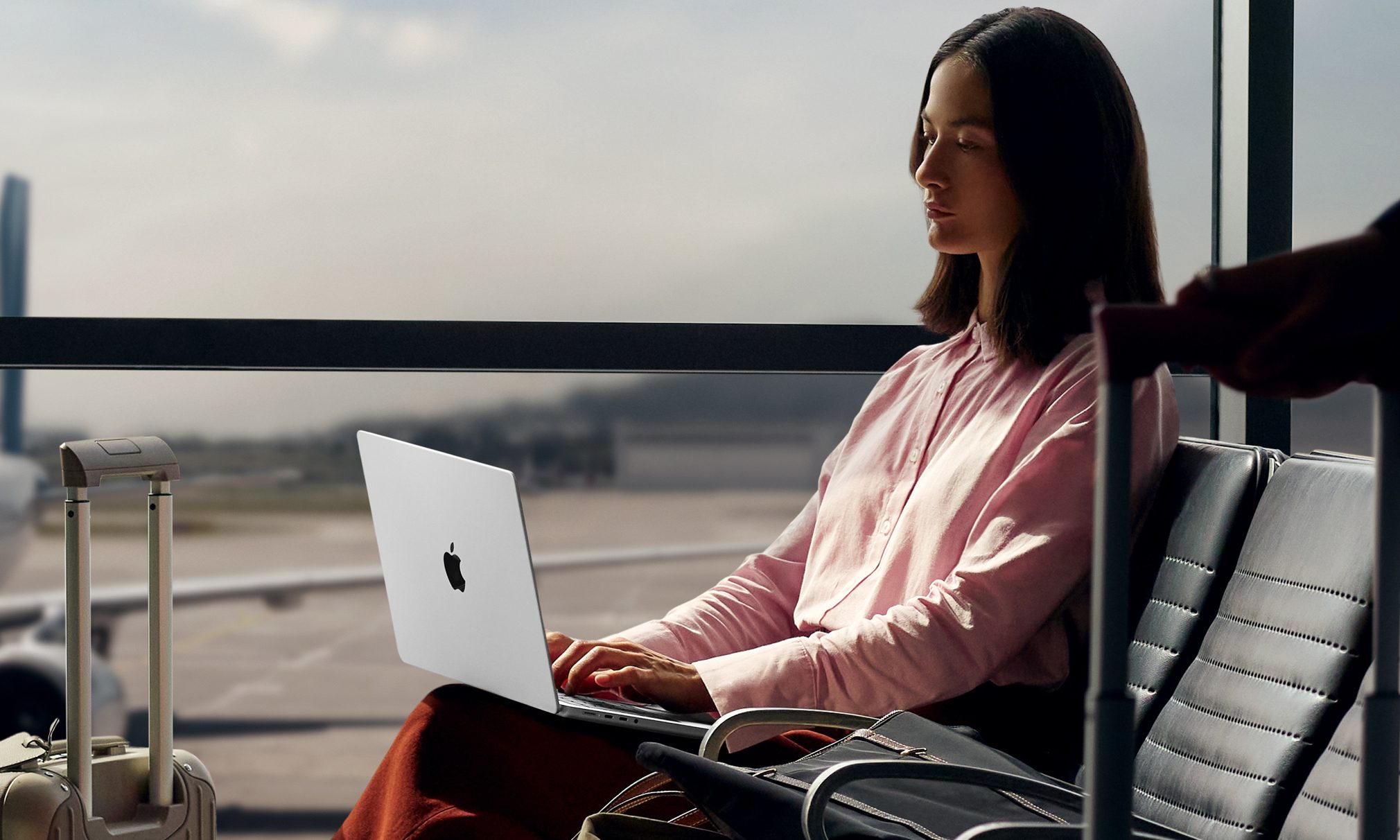 The Apple MacBook Pro 14 M5 sitting on a woman's lap at the airport.