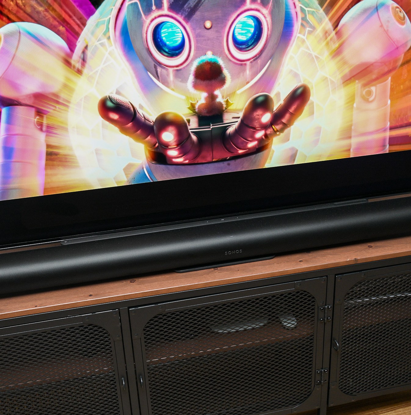 A photo of the Sonos Arc Ultra soundbar in front of a television on a stand.