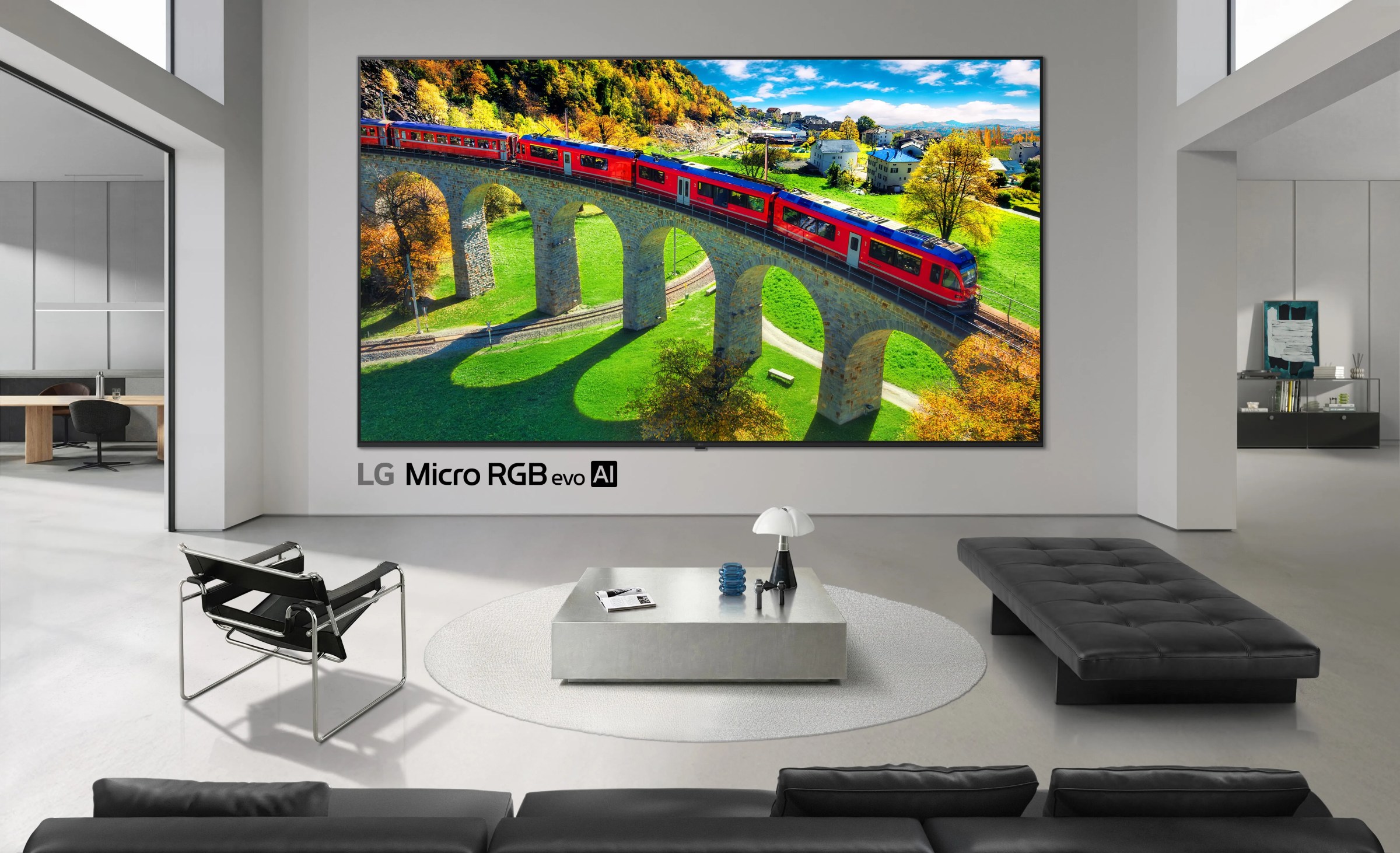 The LG Micro RGB TV in a white living room with black couches.