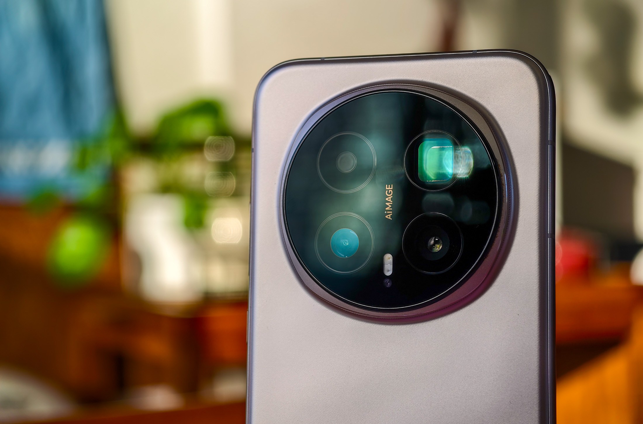 Photo of Honor Magic 8 Pro on a wooden table showing the rear camera with some lens glare