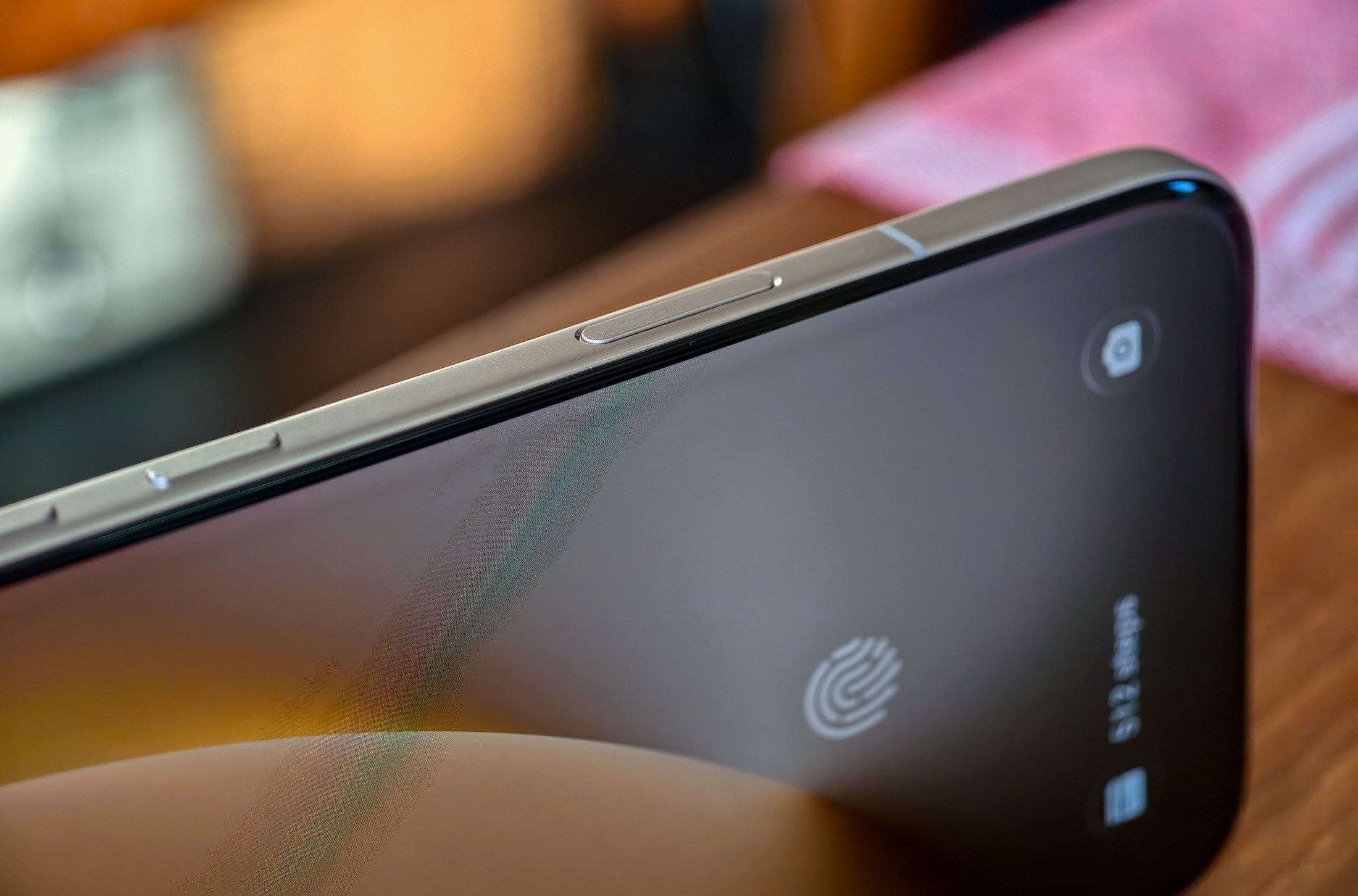 Photo of Honor Magic 8 Pro on a wooden table showing the AI button