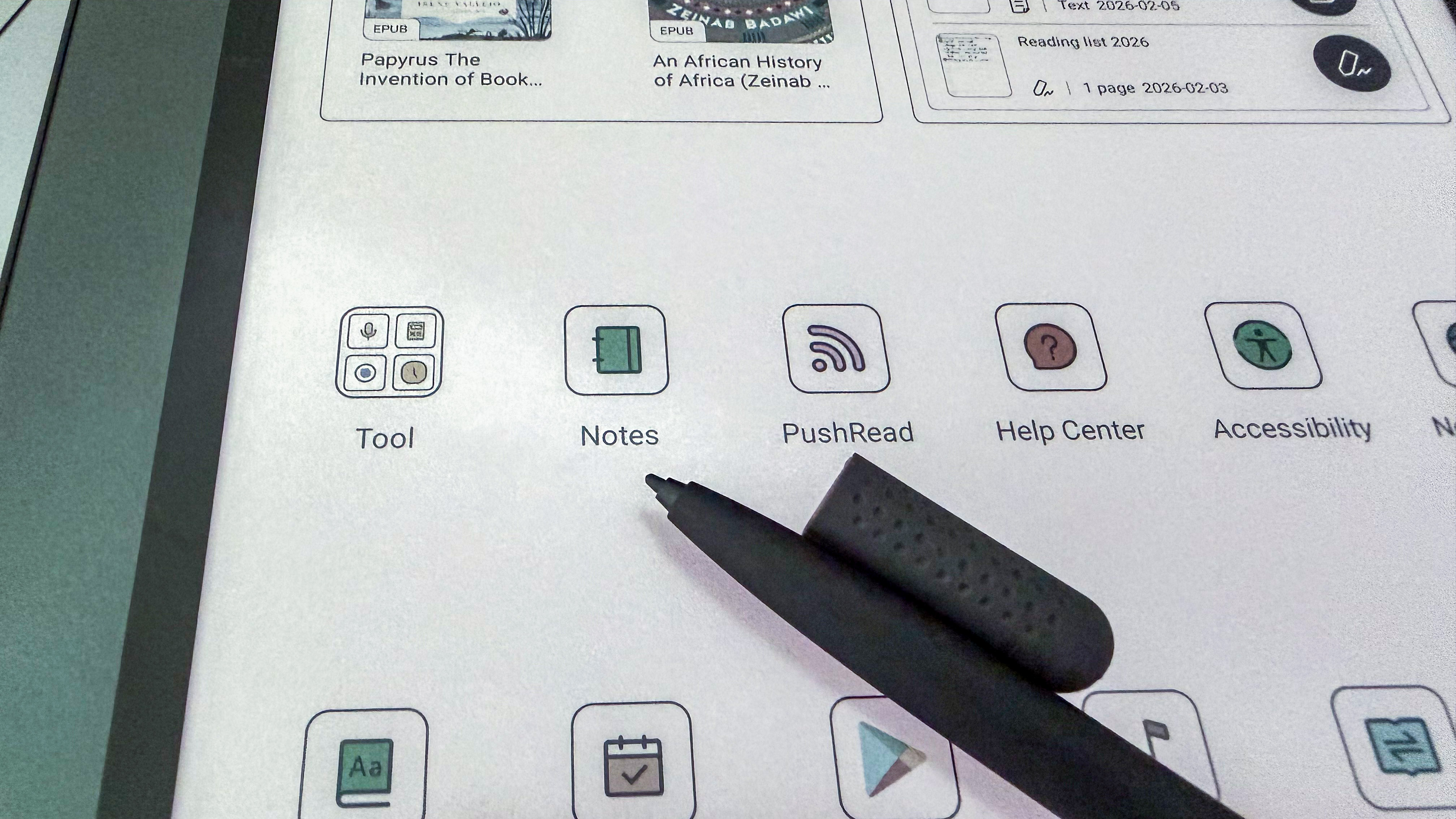 The writing tip of the Boox Pen 3 stylus lying atop the Boox Note Air5 C