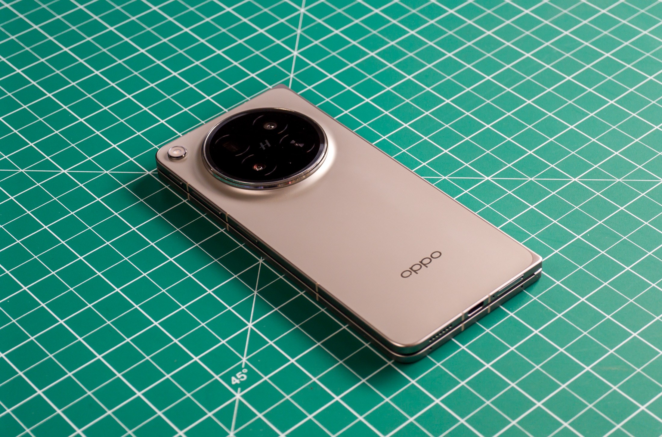 Photo of Oppo Find N6 on a green work mat from above at an angle, closed with the back facing up