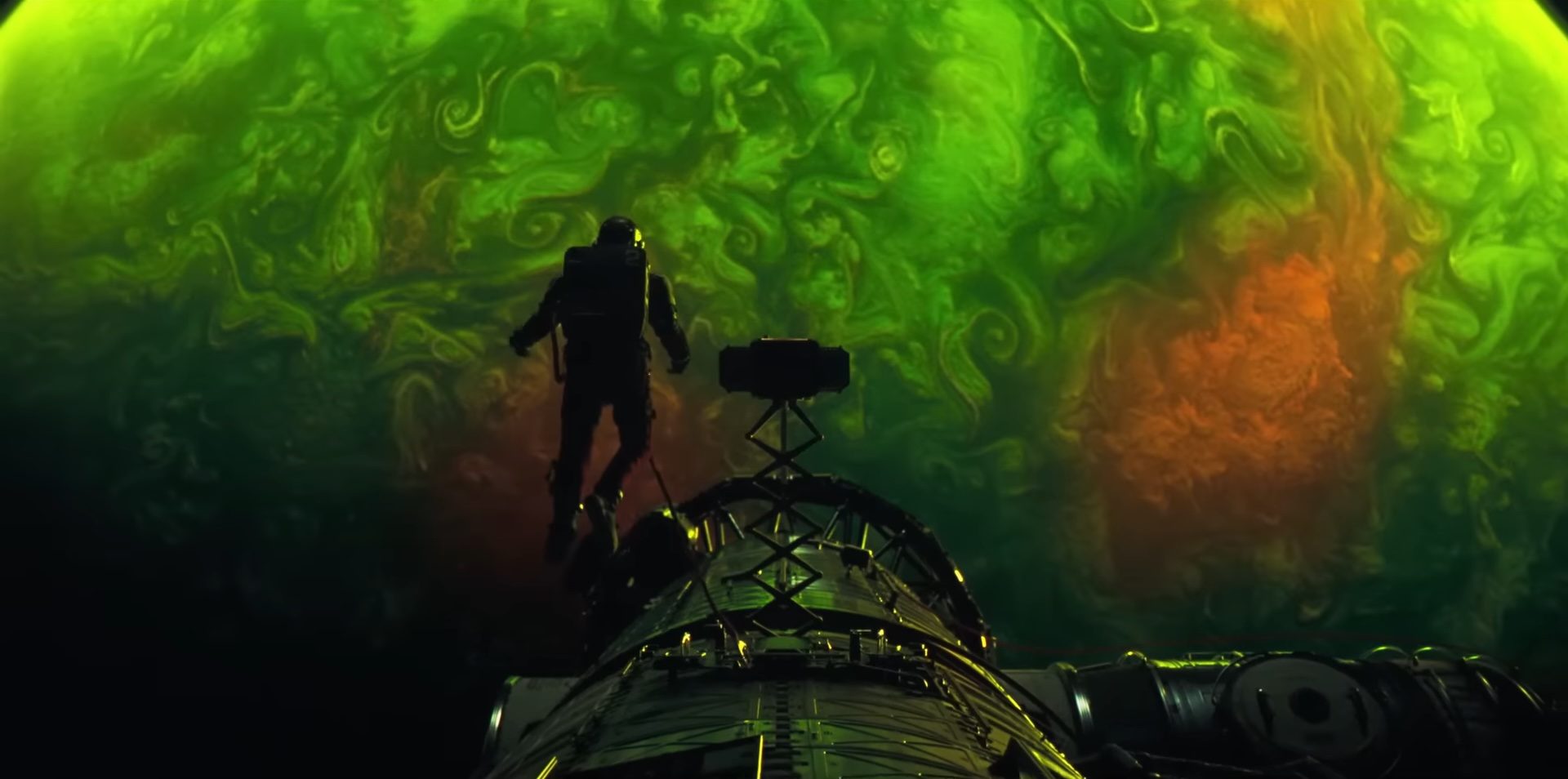 Dr. Ryland Grace (Ryan Gosling) floating in space in front of a green celestial body in the sci-fi film, Project Hail Mary.