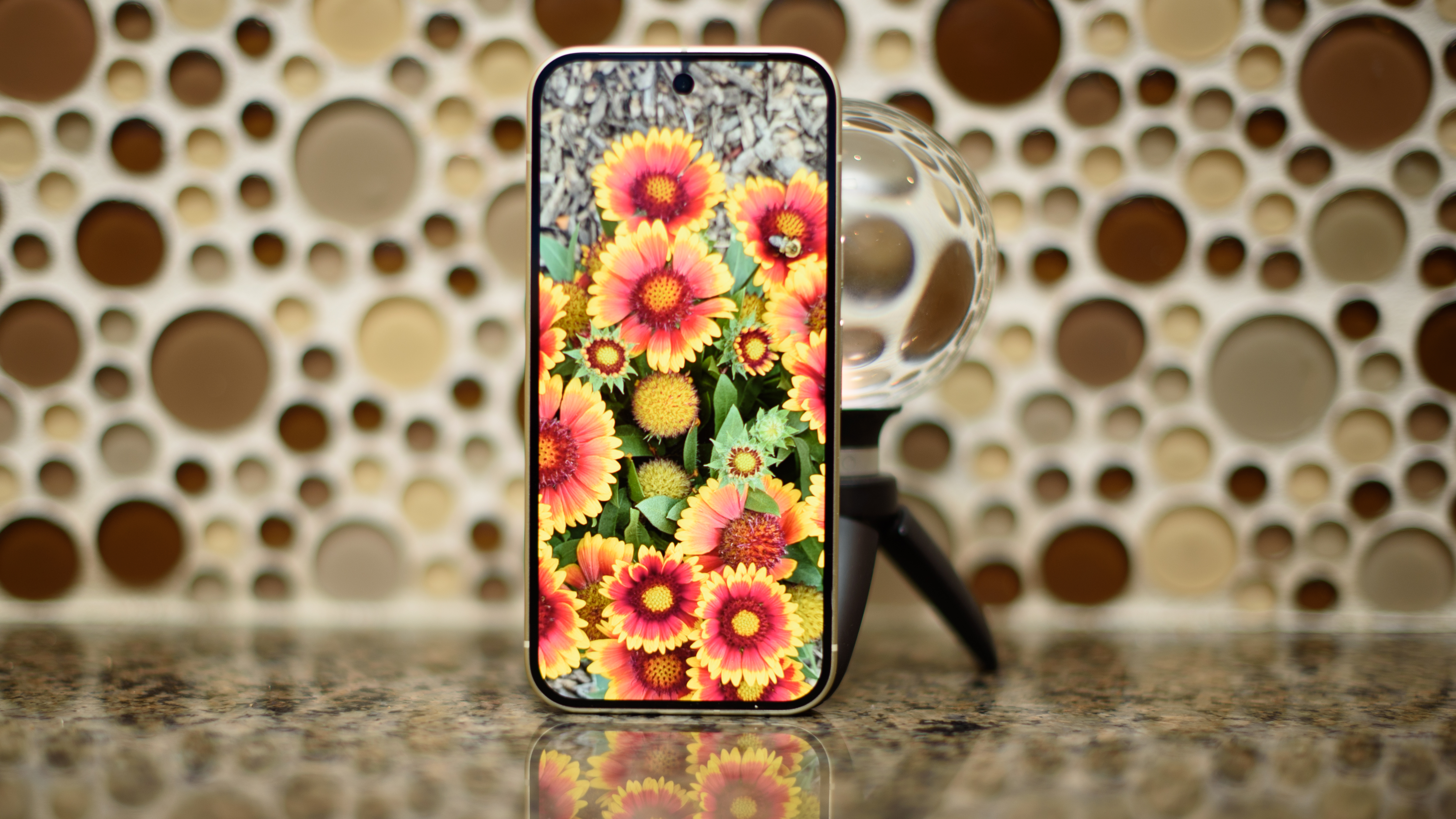 Google Pixel 10 in Lemongrass against a bubbly backsplash