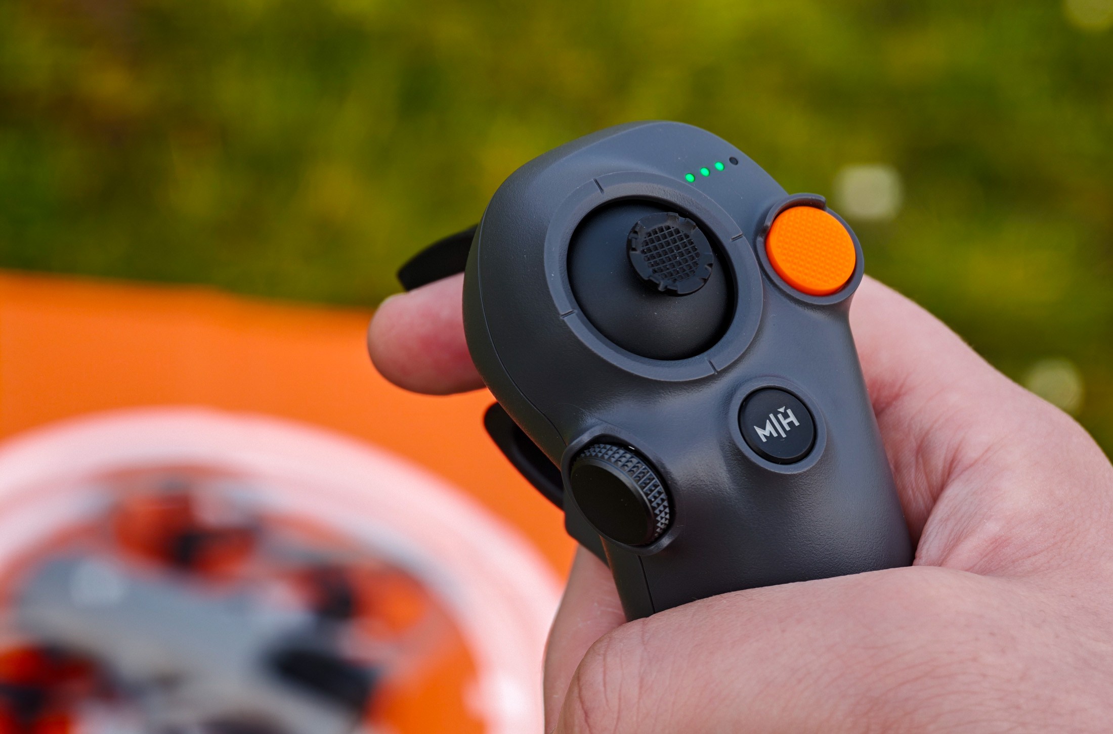 Photo of the DJI RC Motion 3 controller with an Avata 360 in the background