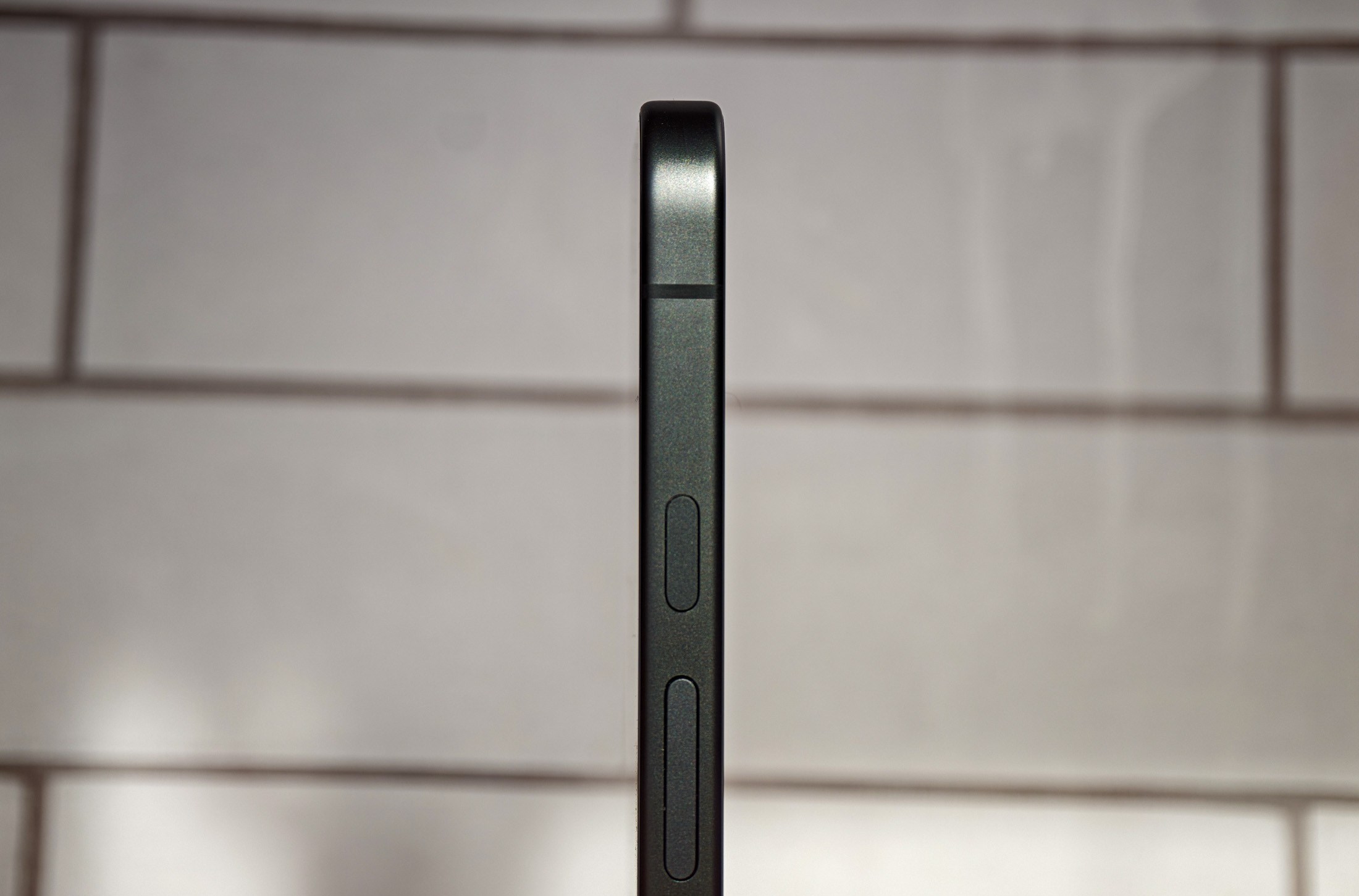 Photo of Google Pixel 10A in front of white tiles, shot from the side to show it’s totally flush