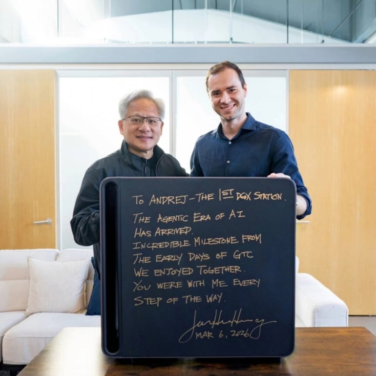 Jensen Huang and Andrej Karpathy holding a chalkboard with a written message about the agentic era of AI.