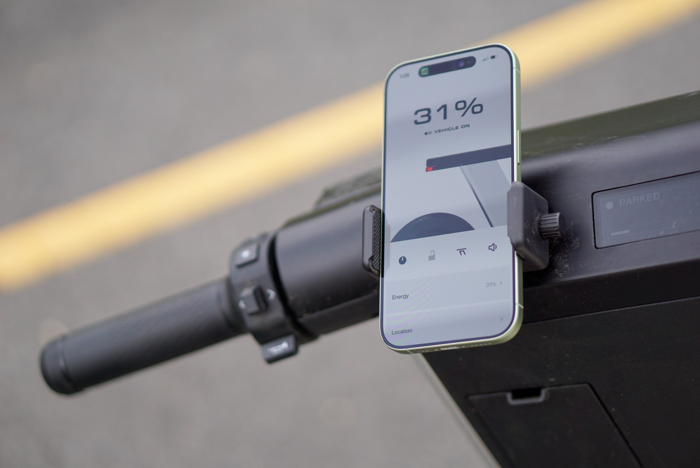 A photo of a phone attached on top of a set of handlebars.