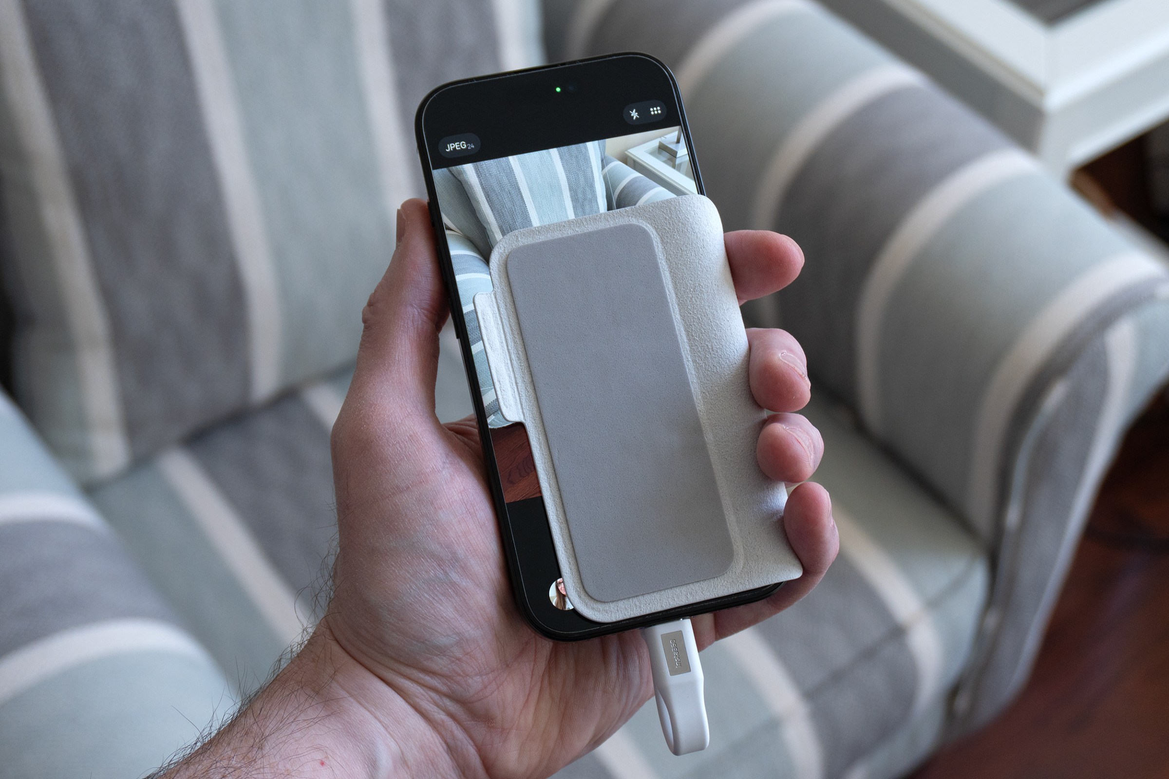 An iPhone with part of its screen covered by the Insta360 Snap screen’s protective cover.