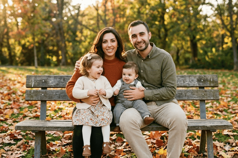 Image result featuring a happy family sitting outside on a bench.