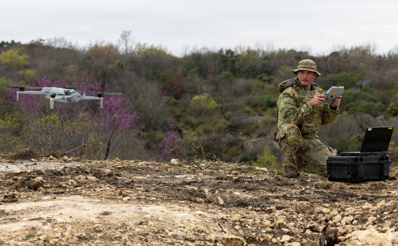 A soldier holding a controller looks at a Skydio X10D folding drone.