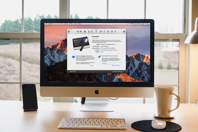 iMac on a white desk displaying the MacPilot system optimization software interface near a window.