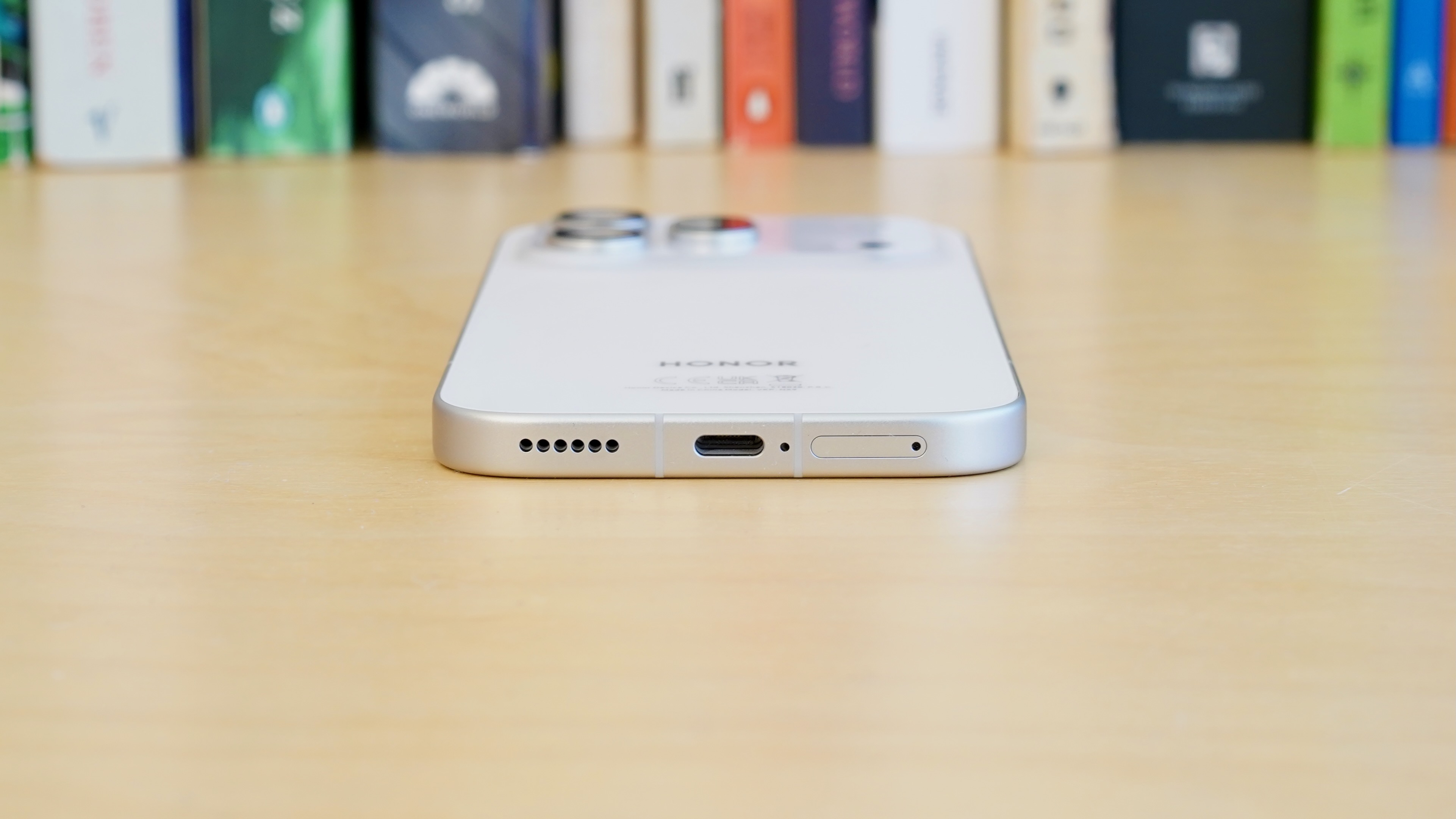 A white Honor 600 Pro resting on a wooden table