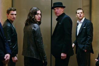 A group of four people stand in an elevator in Now You See Me 2.