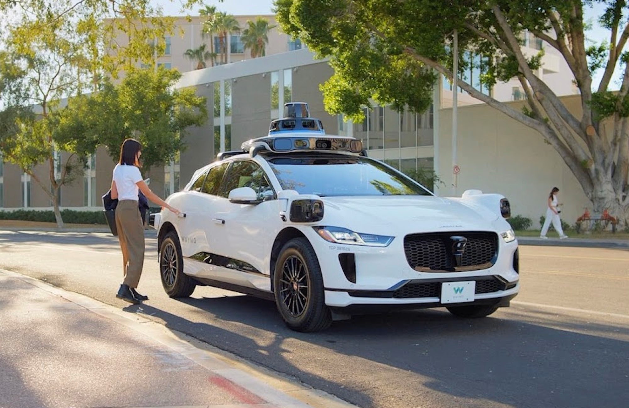 A Waymo robotaxi picking up a passenger.