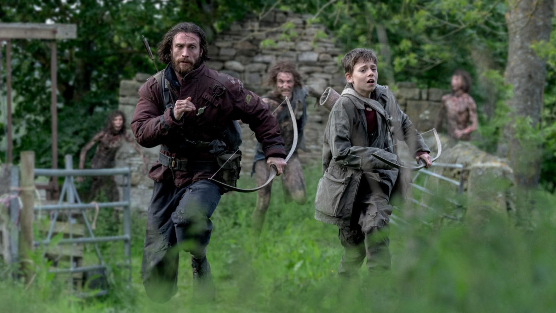 Jamie (Aaron Taylor-Johnson) and Spike (Alfie Williams) run away from zombies in 28 Years Later.