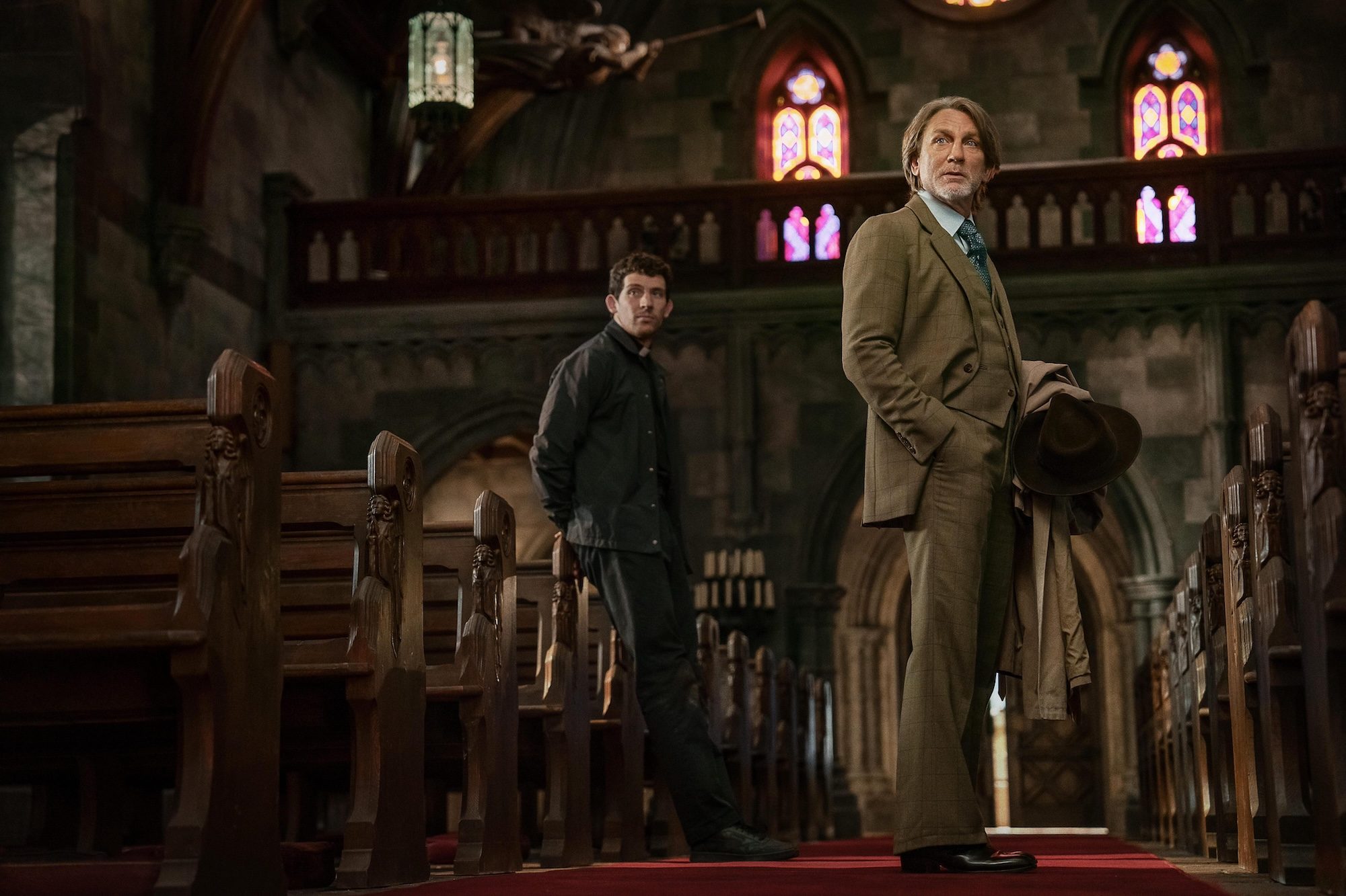 Daniel Craig and Josh O'Connor stand in a church in Knives Out 3.