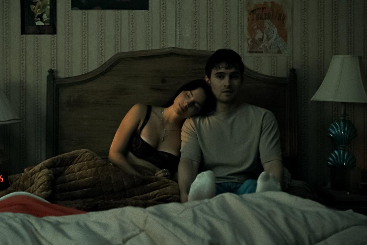 Nikki (Inde Navarette) and Bear (Michael Johnston) on a bed in the horror film, Obsession, written and directed by Curry Barker.