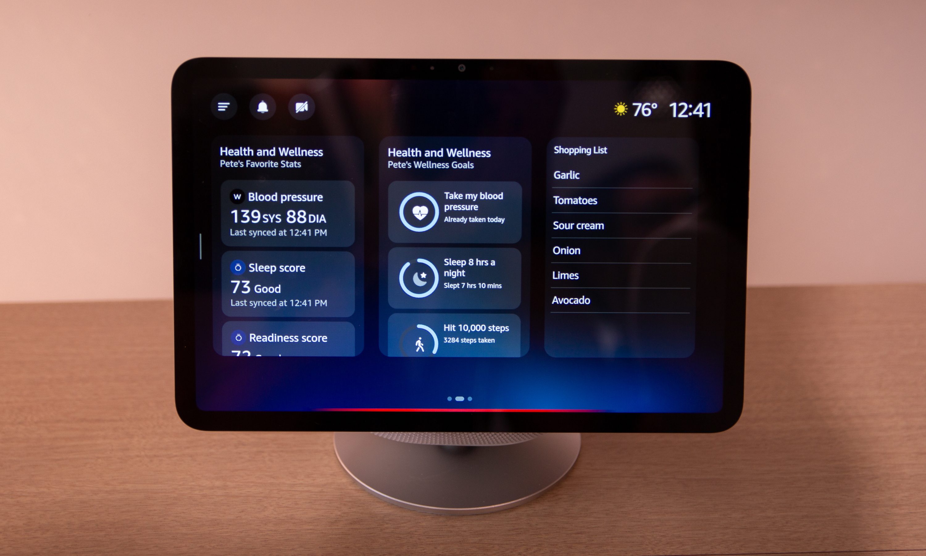 Amazon Echo Show 8 smart speaker sitting on a bench, displaying the weather on screen.