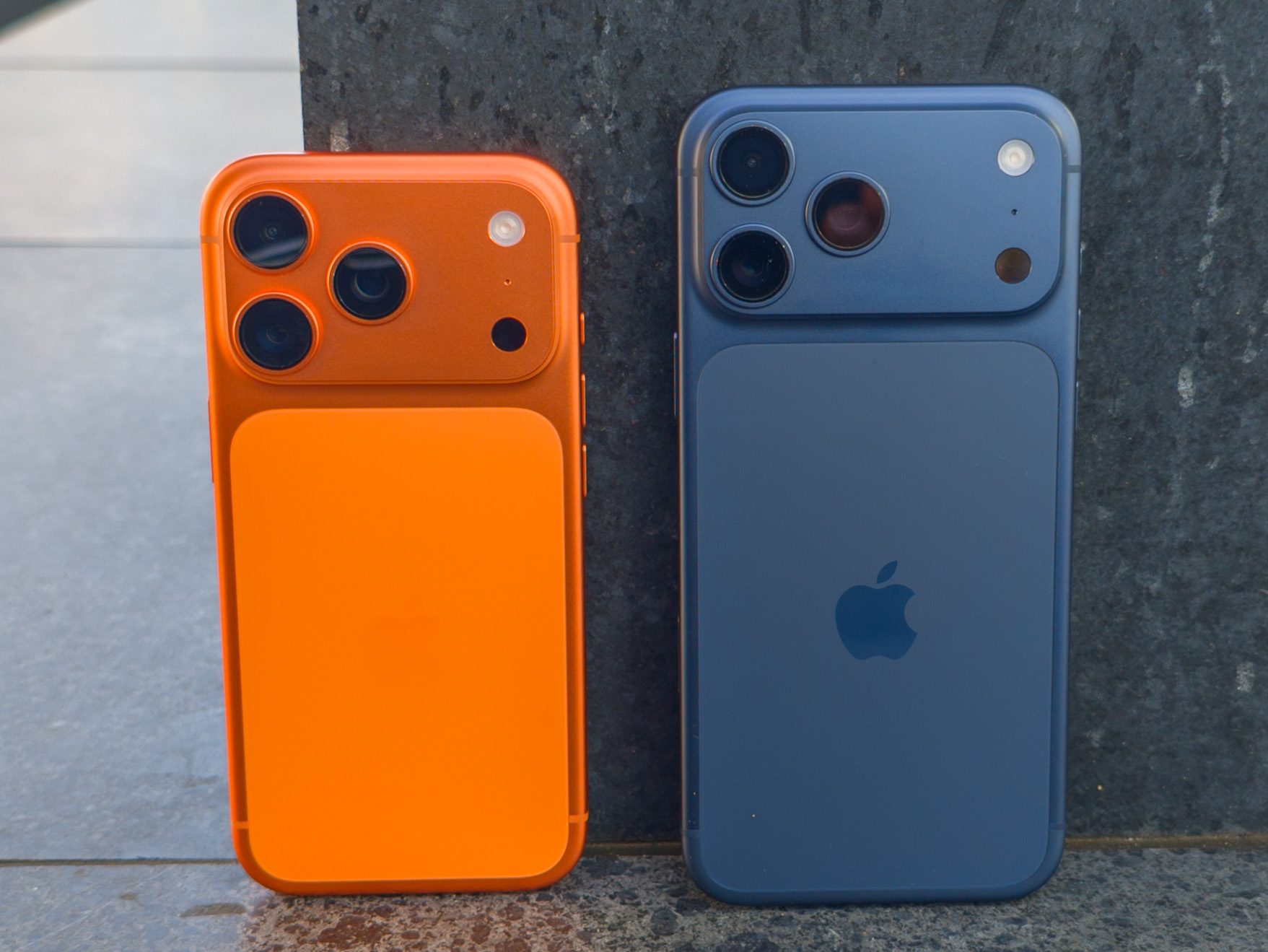 Apple iPhone 17 Pro in Cosmic Orange next to the iPhone 17 Pro Max in Deep Blue