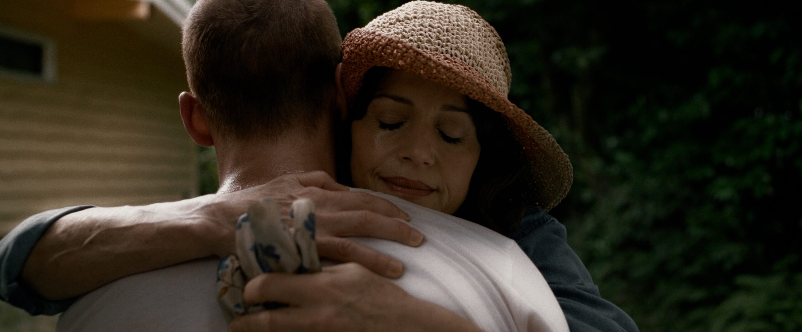 Lou Taylor Pucci and Carla Gugino hugging in the horror film, Lockbox.