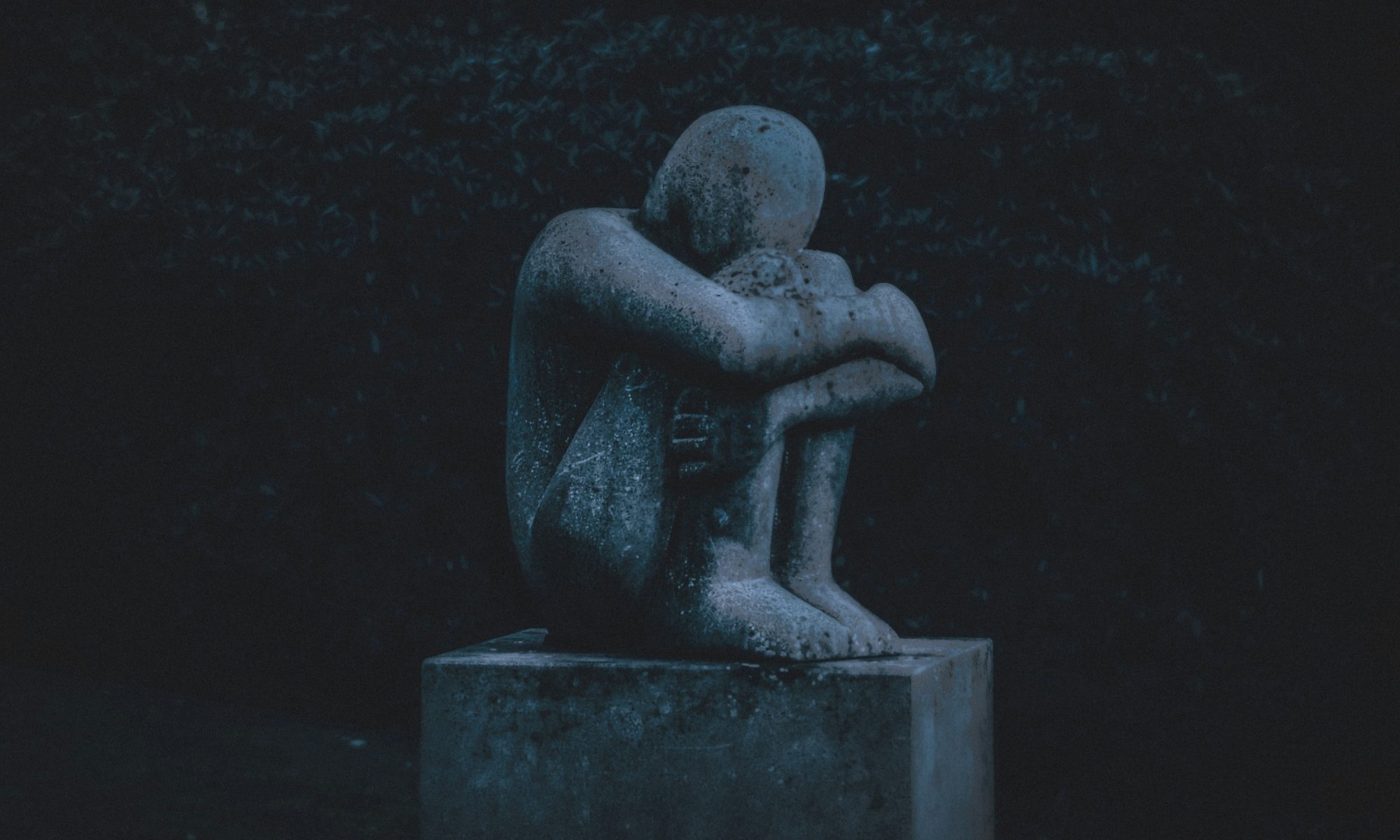 statue hugging its knees