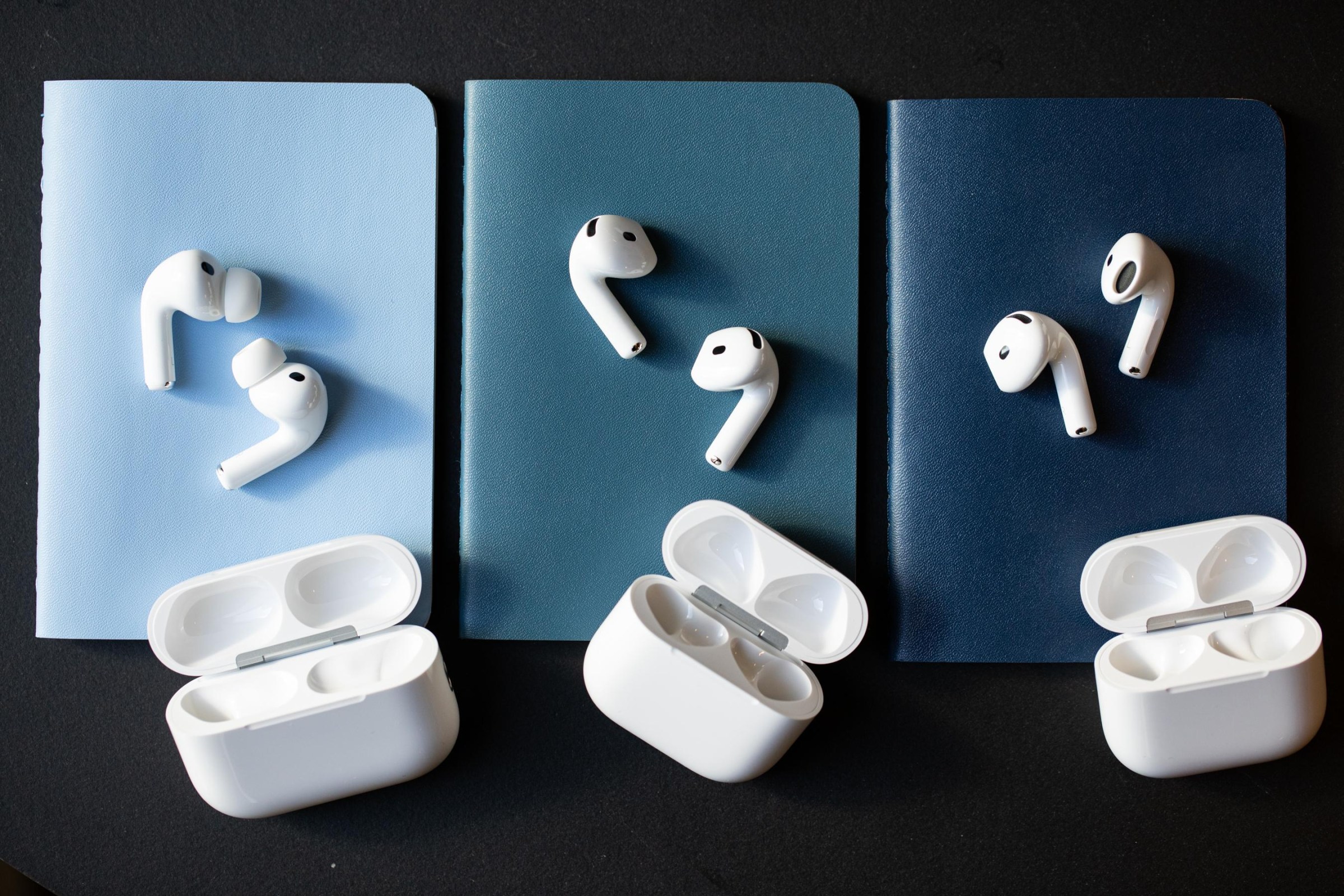 The AirPods 5 (right) share the exterior design as the AirPods 4 (middle), and are inspired by the internal acoustic architecture of the AirPods Pro 3 (left).